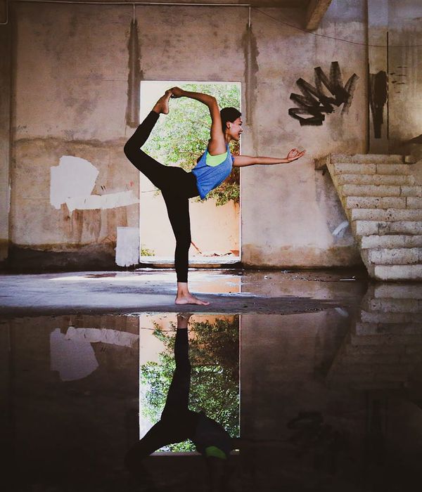 Woman in a graceful yoga pose in a bright, calm room.